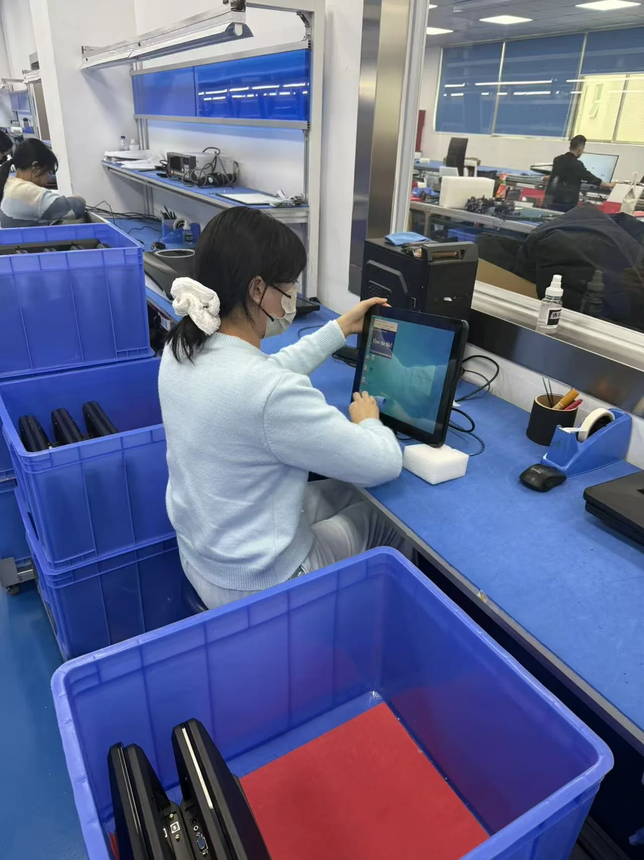Operator inspecting a completed monitor at Yanxun Display